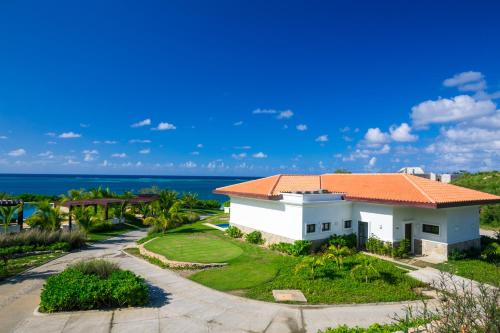 an aerial view of a white house with an orange roof at Pristine Bay Beach Home 104 in French Harbour