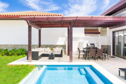 a patio with a swimming pool and a pergola at Pristine Bay Beach Home 104 in French Harbour