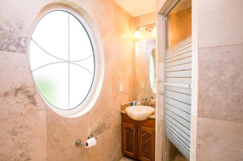 a bathroom with a sink and a round window at Lawson Rock - Angelfish 202 Condo in Sandy Bay