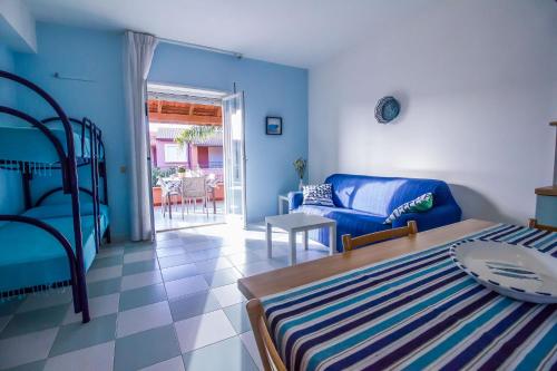 a blue room with a bed and a couch and a table at Residence del Mare CaseSicule in Santa Maria del Focallo