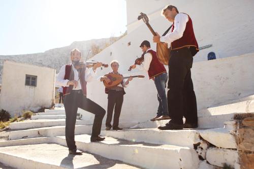 a group of men playing music on the stairs at Aegialis Hotel & Spa in Aegiali