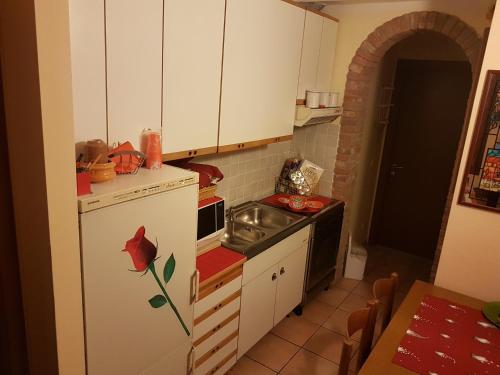 uma pequena cozinha com um frigorífico branco e um fogão em B&B Kristina em Quinto Vicentino