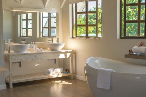 a bathroom with two sinks and a tub at Le Nautique Waterfront Hotel La Digue in La Digue