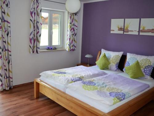 a bedroom with a large bed with purple walls at Ferienhof Nirschl in Winzer
