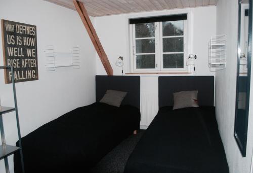 a small room with two beds and a window at Adventure Park Apartments in Ringkøbing