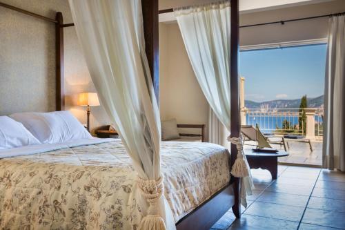 a bedroom with a bed and a balcony with a view at Almyra Hotel in Fiskardo