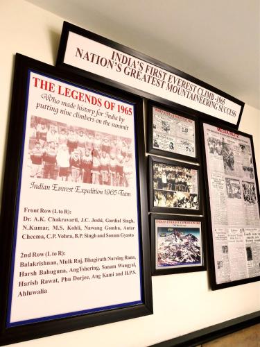 a wall with three framed newspapers and a poster at The Legend Inn Delhi in New Delhi