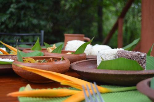 a wooden table with plates of food on it at Dambulla Tree House in Dambulla