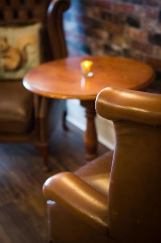 a wooden table and a chair with a candle on it at Lamlash Bay Hotel in Lamlash