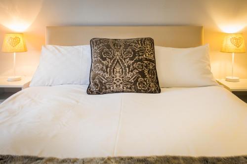 a white bed with a pillow on top of it at Lamlash Bay Hotel in Lamlash