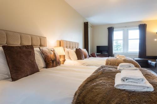 a bedroom with two beds with towels on them at Lamlash Bay Hotel in Lamlash