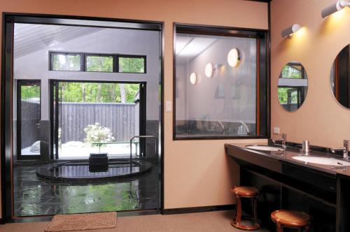 a bathroom with two sinks and a large window at Log Cottage Epoch in Hakuba