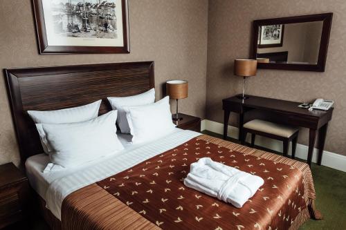 a hotel room with a bed with towels on it at Chaika Hotel in Kaliningrad