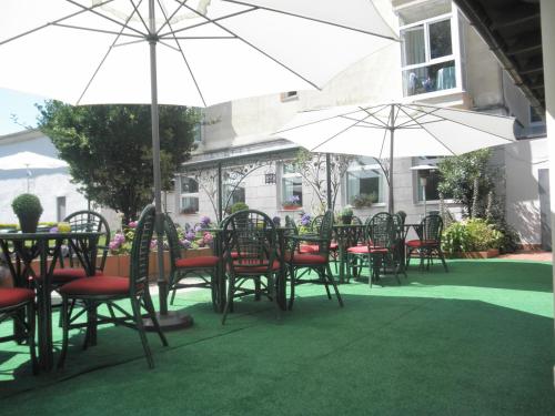a group of tables and chairs with umbrellas at Hotel Balneario De Alceda in Alceda