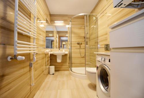 a bathroom with a shower and a toilet and a sink at Rezydencja Park, Sun & Snow in Mielno