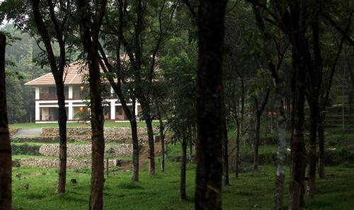 a house in the middle of a forest at Windermere River House in Neriyamangalam