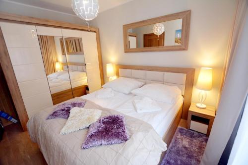 a bedroom with a bed and a large mirror at Rezydencja Park, Sun & Snow in Mielno