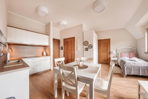 a kitchen and dining room with a table and chairs at Rezydencja Park, Sun & Snow in Mielno