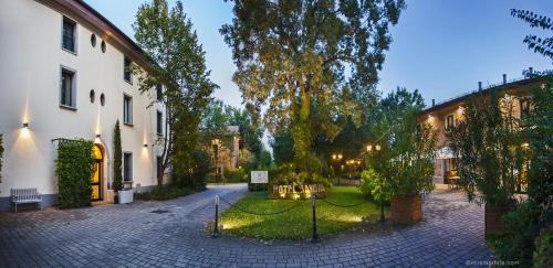 a courtyard of a building with trees and a building at Savoia Hotel Country House Bologna in Bologna