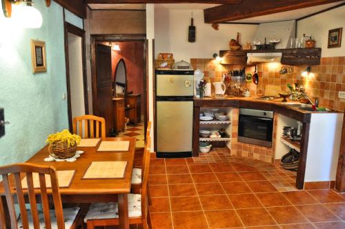 a kitchen with a table and a refrigerator at Tvrdic Honey in Grohote