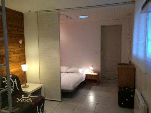 a small bedroom with a bed and a mirror at Monta in Montalivet-les-Bains