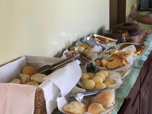 a table topped with trays of different types of pastries at Pousada Mabuya in Fernando de Noronha