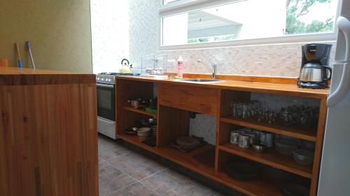 Una cocina con encimera con fregadero y estufa. en Olivo de Bohemia, en Mar de las Pampas