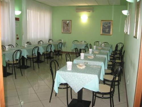 una stanza piena di tavoli e sedie con tovaglie blu di Albergo Elena a Pianoro