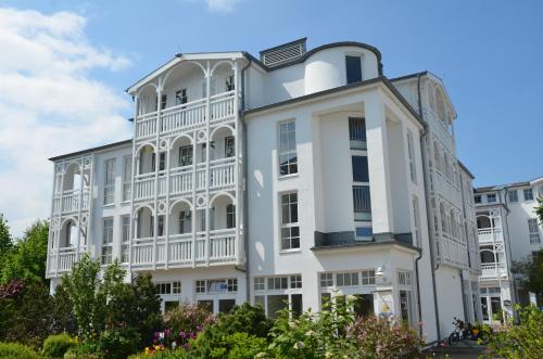 Großes weißes Gebäude mit Balkon in der Unterkunft Seepark Sellin - Apt. 635 in Ostseebad Sellin