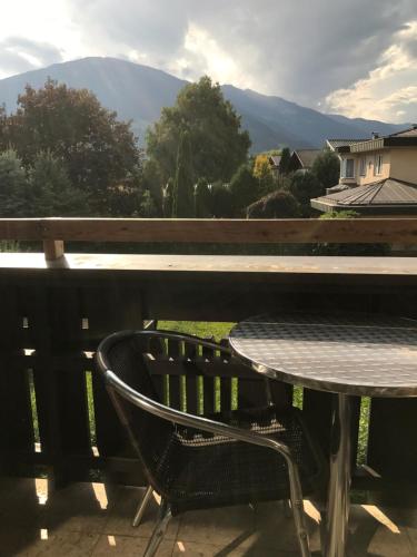 uma mesa e cadeira numa varanda com vista em Bel'vue em Lienz