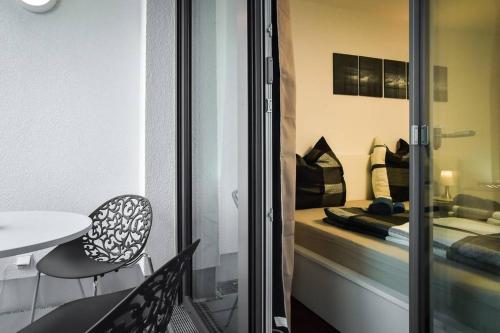 a room with a bed and a table and a chair at Deluxe Ferienwohnung Apartment Stuttgart Centre/Milaneo in Stuttgart