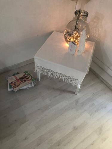 una mesa blanca con una lámpara y una vela en ella en Mansarda al mare, en Rímini
