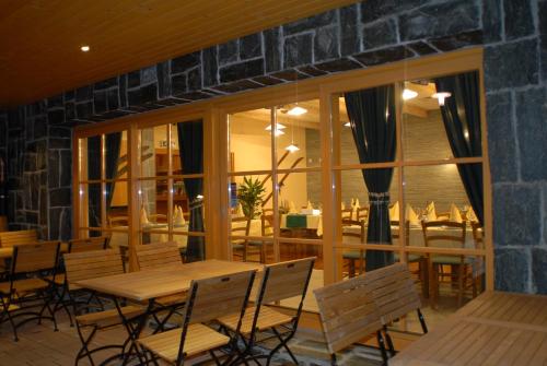 a restaurant with wooden tables and chairs and windows at Aparthotel Snjezna Kraljica in Zagreb