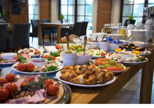 a table with many plates of food on it at Hotel Kuźnia Smaków in Małe Pułkowo