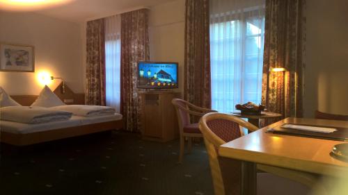 ein Hotelzimmer mit einem Bett und einem TV in der Unterkunft Hotel Marxzeller Mühle in Marxzell