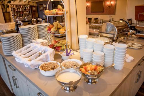 a buffet with plates and bowls of food on a counter at Hof van Putten in Putten