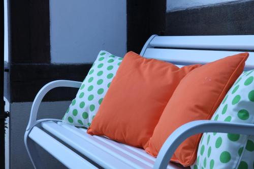 an orange pillow and polka dot pillows on a chair at Historik Hotel Garni Christinenhof in Hameln