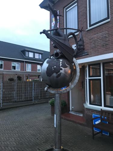 a globe on a pole in front of a building at City Hotel Meppel in Meppel