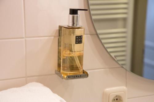 un distributeur de savon sur un lavabo devant un miroir dans l'établissement Hof van Putten, à Putten