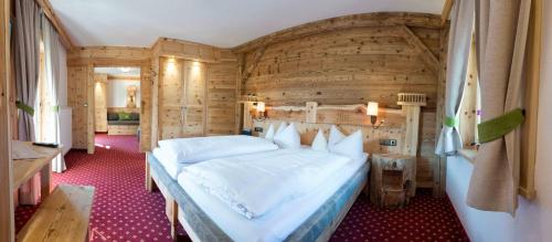 a bedroom with a large bed with a wooden wall at Gröbl-Alm in Mittenwald