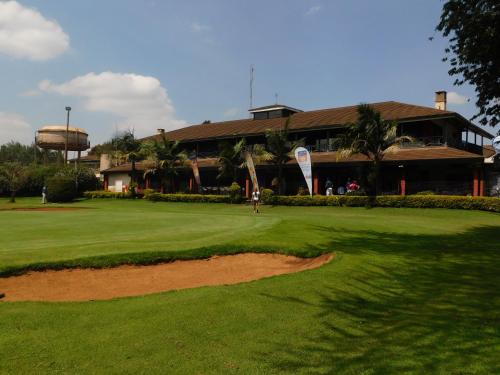 KikuyuにあるSigona Golf Clubの建物前のゴルフ場に立つ男