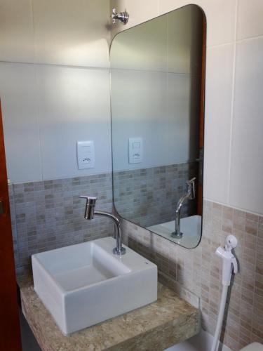 a bathroom with a white sink and a mirror at Mariba's Pousada in João Pessoa