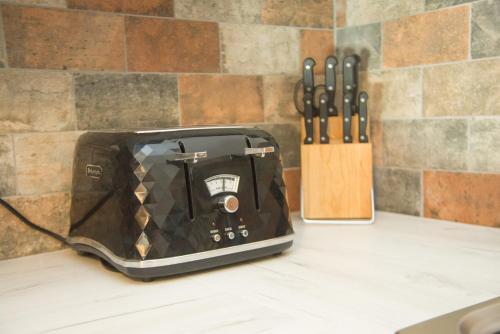 a toaster sitting on a counter next to a knife block at Barnston House - Heswall - spacious homely holiday home by Rework Accommodation in Heswall