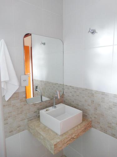 La salle de bains est pourvue d'un lavabo blanc et d'un miroir. dans l'établissement Mariba's Pousada, à João Pessoa