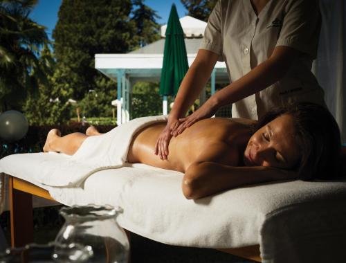 a woman getting a back massage on a bed at Grand Hotel Imperial in Levico Terme
