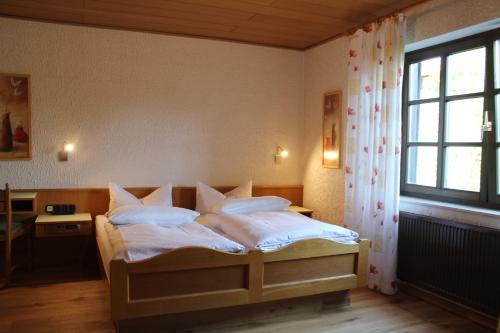 a bedroom with a bed with white sheets and a window at BELVEDERE Appart & Chalet - Ihr Zuhause auf Zeit am Edersee - Ihr Geschenk die GästeCard GrimmHeimat in Waldeck