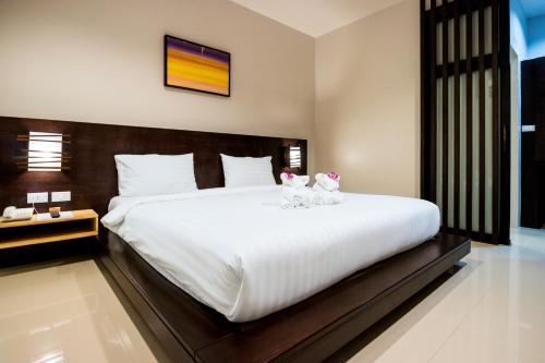two cats sitting on a bed in a bedroom at S2 Residence in Ao Nang Beach
