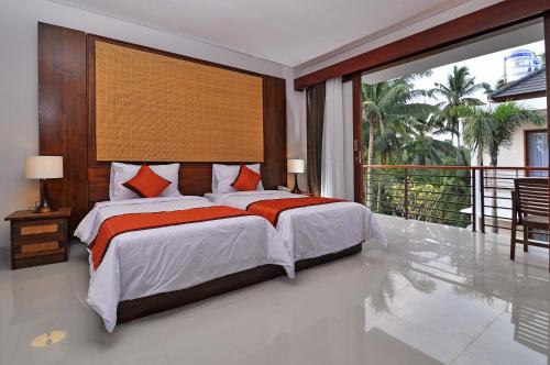a bedroom with a large bed and a balcony at Pertiwi Bisma 1 in Ubud