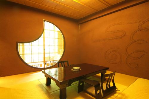 a dining room with a table and a window at Shiunso in Hakone