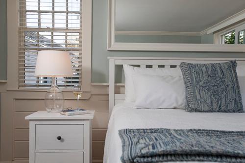 a bedroom with a bed with a lamp and a window at Chatham Seafarer Inn in Chatham